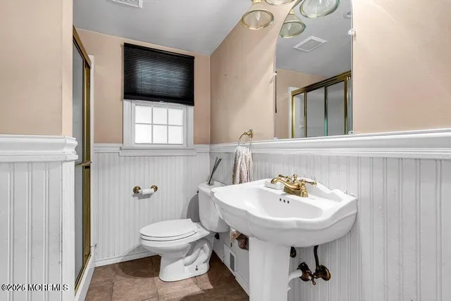 a bathroom with a sink toilet and a mirror