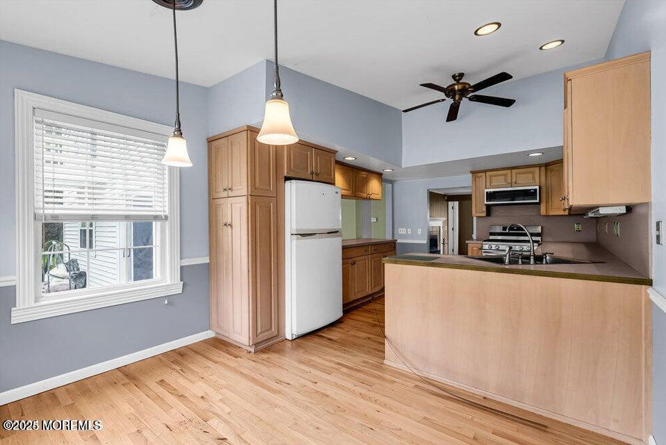 150 Easy Street Howell, NJ 07731 - Photo 17 of 23 a kitchen with stainless steel appliances granite countertop a refrigerator a stove a sink dishwasher and a dining table with wooden floor