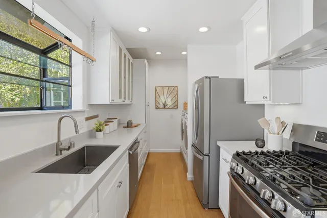 a kitchen with stainless steel appliances granite countertop a sink stove and refrigerator