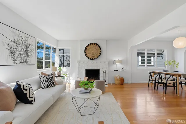 a living room with fireplace furniture and a wooden floor