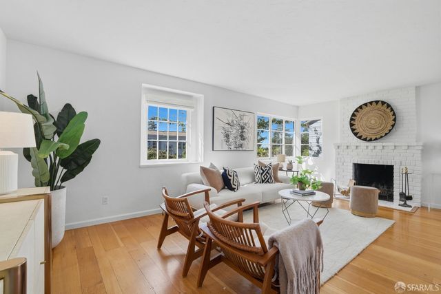 a living room with furniture a fireplace and a potted plant