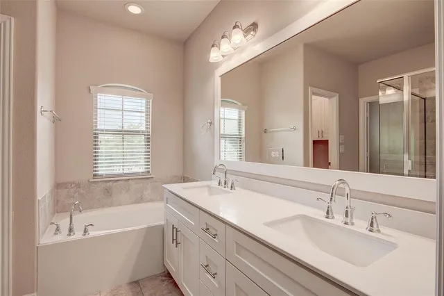a bathroom with a tub double sink and mirror
