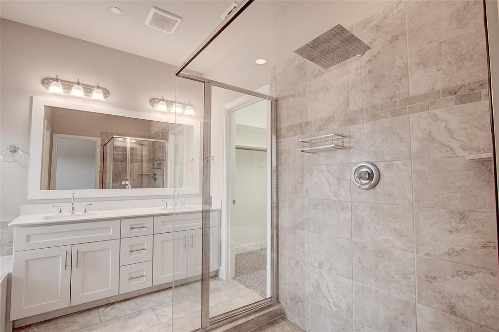 6156 Rilla Street Frisco, TX 75035 - Photo 19 of 32 a bathroom with a granite countertop sink a mirror and a shower
