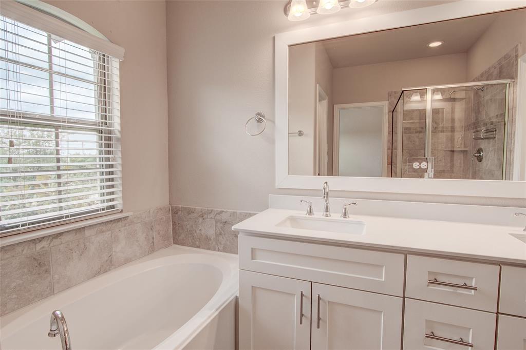 6156 Rilla Street Frisco, TX 75035 - Photo 30 of 32 a bathroom with a tub sink and mirror