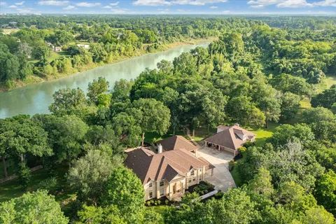 an aerial view of a house with a yard and lake view