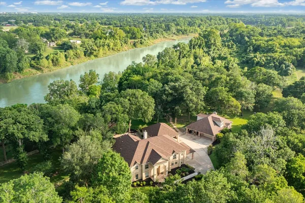 an aerial view of a house with a yard and lake view