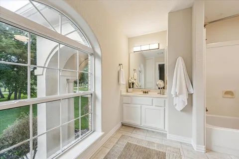 a bathroom with a granite countertop sink mirror and bathtub