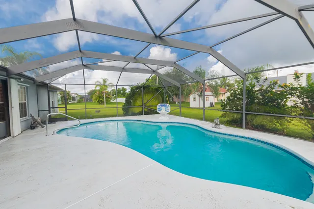 a view of a house with a big yard and a large tree with wooden fence