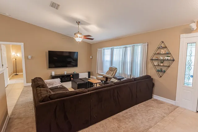 a living room with furniture a flat screen tv and a window