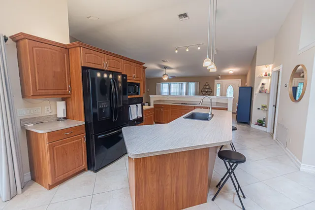 a kitchen with stainless steel appliances kitchen island a refrigerator sink and cabinets