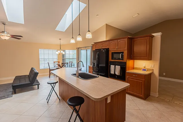 a kitchen with stainless steel appliances granite countertop a sink and a refrigerator