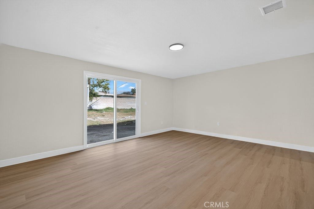 606 East Jackson Street Rialto, CA 92376 - Photo 26 of 29 an empty room with wooden floor and windows
