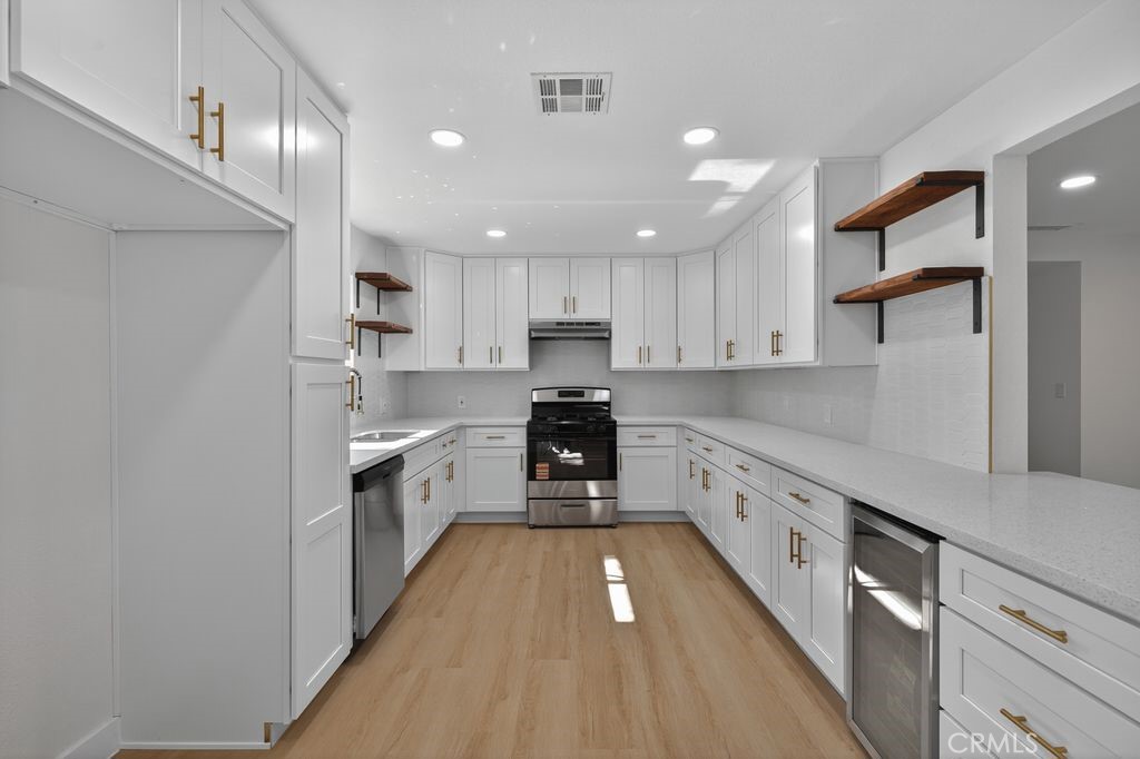 606 East Jackson Street Rialto, CA 92376 - Photo 8 of 29 a large kitchen with stainless steel appliances granite countertop a sink and cabinets