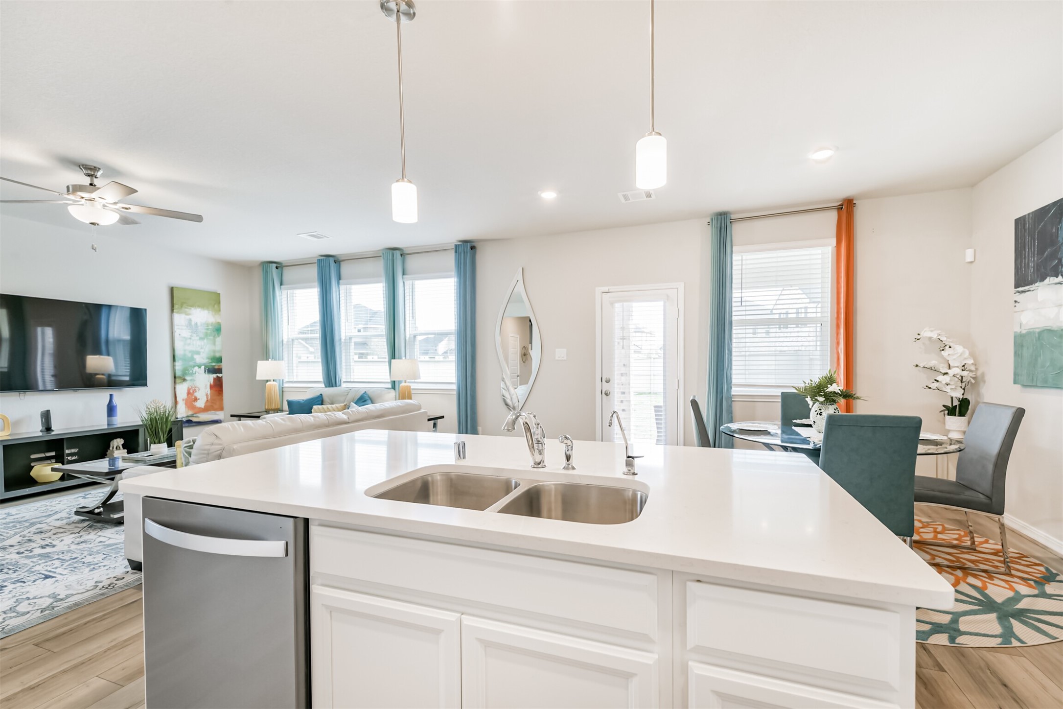 17465 Buckeye Branch Conroe, TX 77385 - Photo 12 of 47 This modern kitchen features sleek white cabinets, a spacious island with a sink, and elegant pendant lighting, add warmth and functionality, while the stainless steel appliances complete the contemporary look.