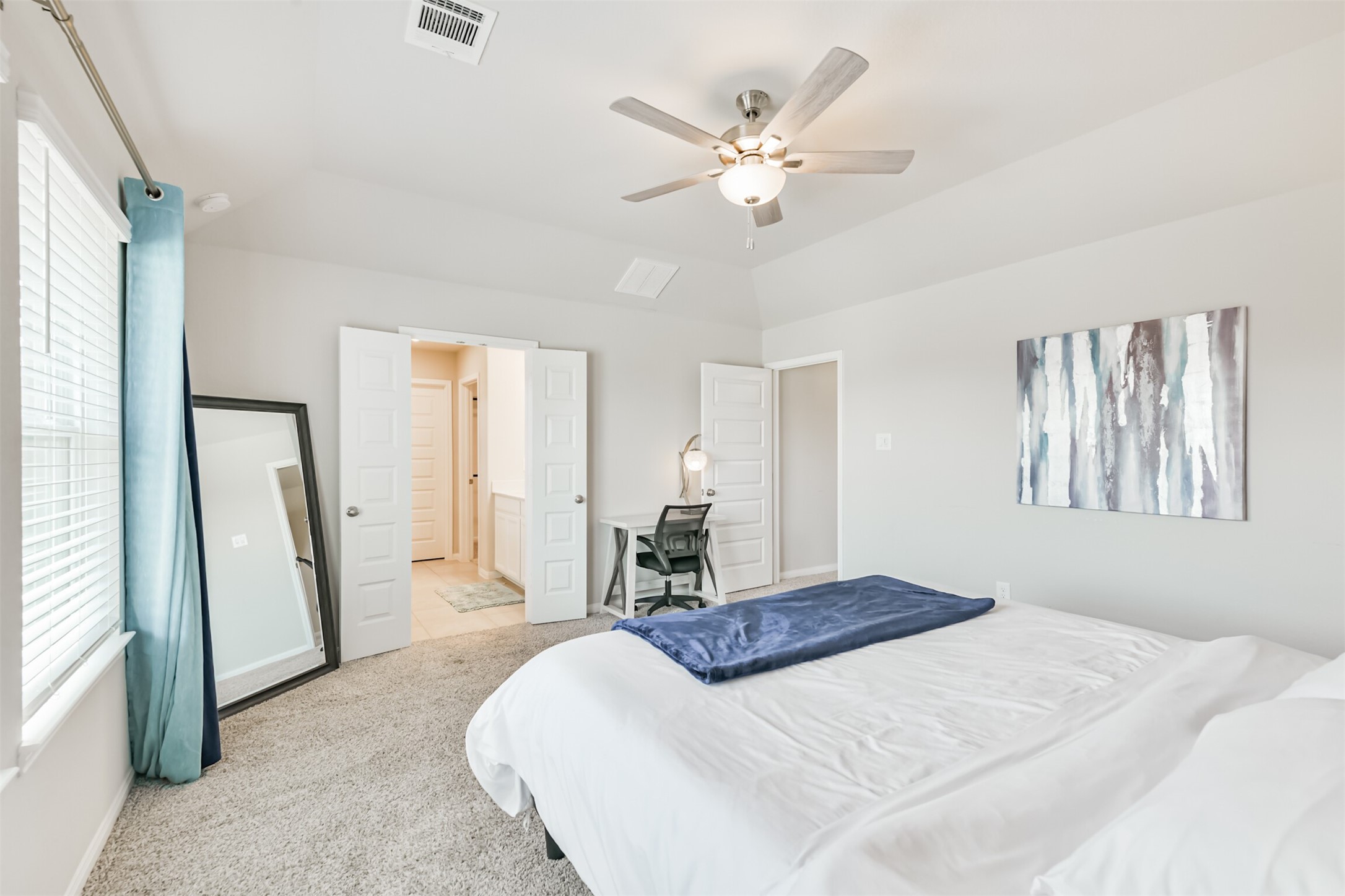 17465 Buckeye Branch Conroe, TX 77385 - Photo 20 of 47 Large primary bedroom features soft carpet and neutral walls, leading to a primary spa-like bathroom with double doors.