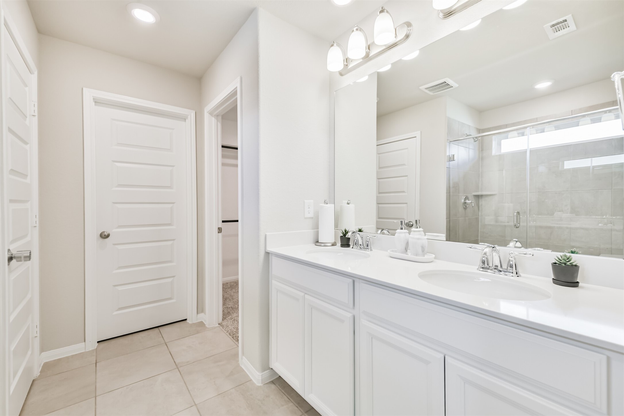 17465 Buckeye Branch Conroe, TX 77385 - Photo 22 of 47 The Primary bathroom features a spacious layout with a large mirror, and a large walk-in shower. It has sleek walls, tiled flooring, and ample natural light.