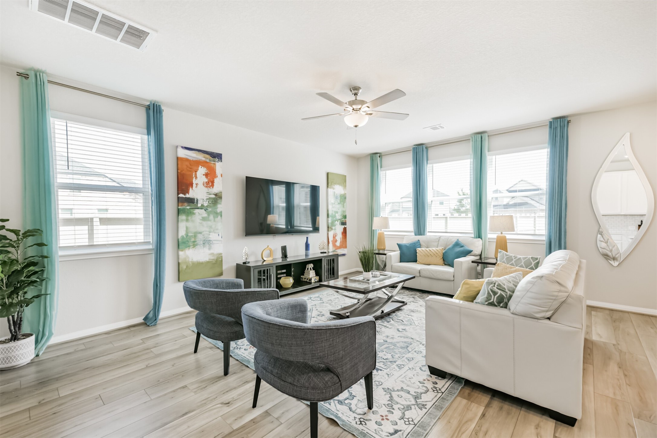 17465 Buckeye Branch Conroe, TX 77385 - Photo 5 of 47 Bright and inviting living area with modern features, open layout with wood-style flooring and ample natural light, creating a warm and welcoming atmosphere.