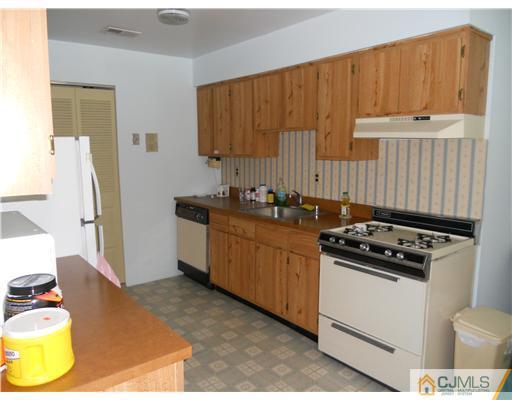 1624 Raspberry Court Edison, NJ 08817 - Photo 6 of 7 a kitchen with a stove a refrigerator and wooden cabinets