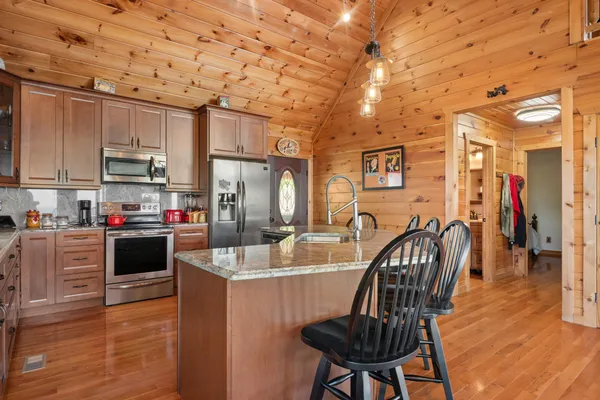 a view of a livingroom with furniture a rug a fireplace and windows