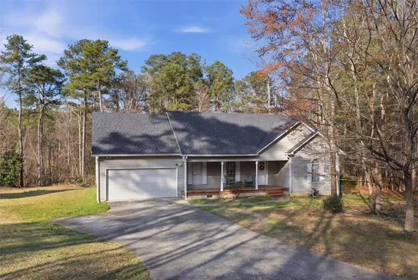 a view of a house with a yard and large tree