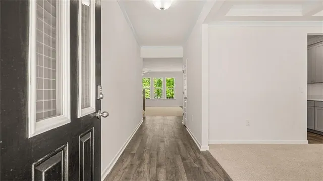 a view of a hallway with wooden floor and a window
