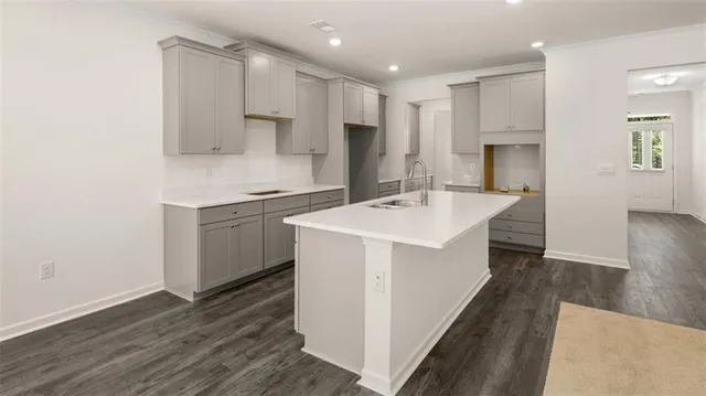 a kitchen with a sink a counter top space stainless steel appliances and cabinets