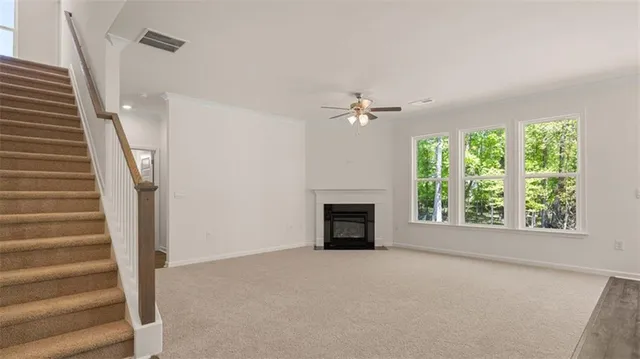 a view of an empty room with window and fire place