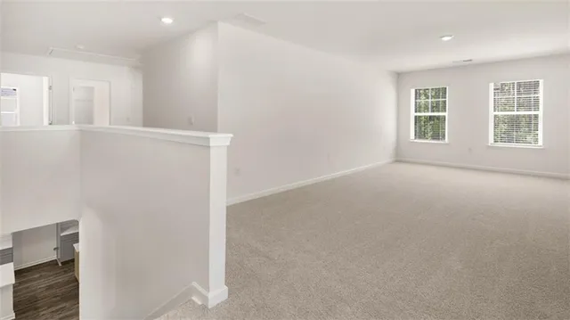 an empty room with windows and refrigerator