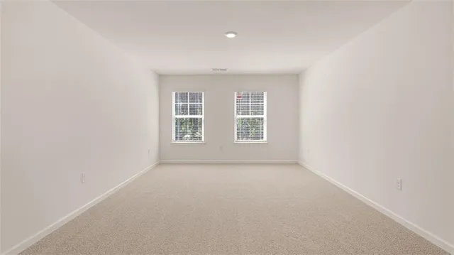 a view of an empty room with closet and mirror