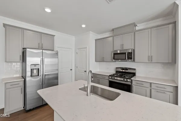 a kitchen with stainless steel appliances kitchen island granite countertop a sink and stove top oven
