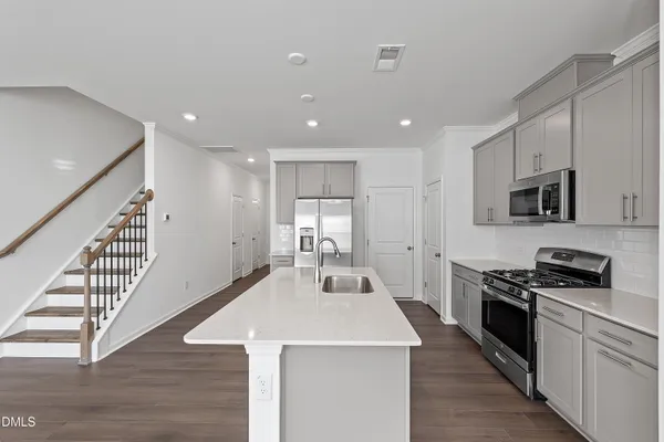 a kitchen with stainless steel appliances white cabinets and a stove top oven