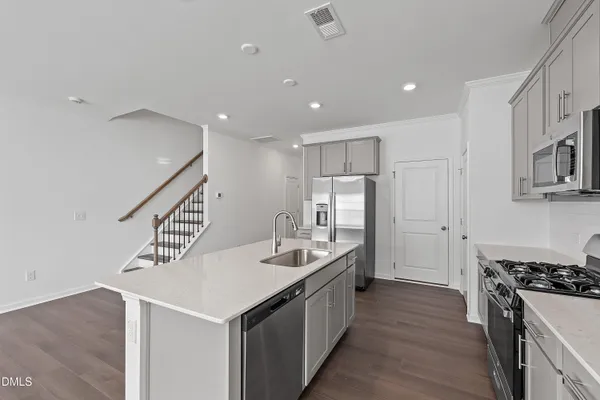 a kitchen with stainless steel appliances a sink stove and cabinets