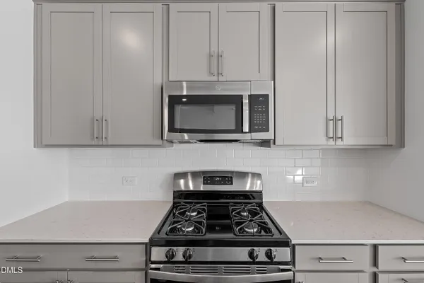 a view of an empty room with wooden floor and windows
