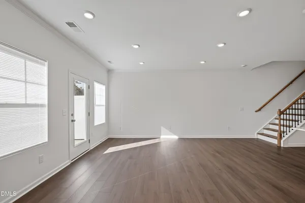 a view of a kitchen with refrigerator and wooden floor