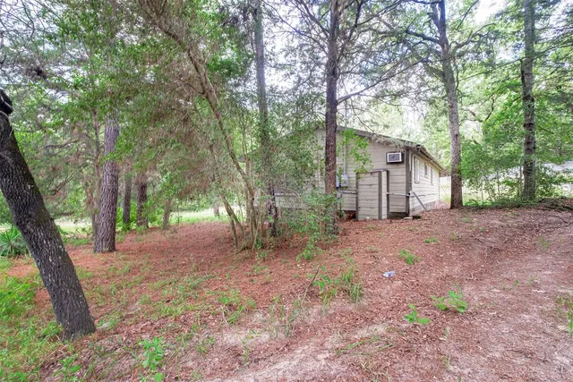 a view of a house with large trees and a small barn