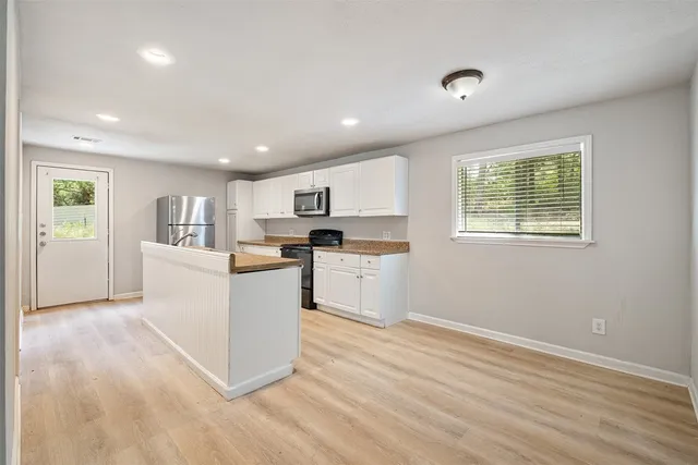 a kitchen with cabinets and wooden floor