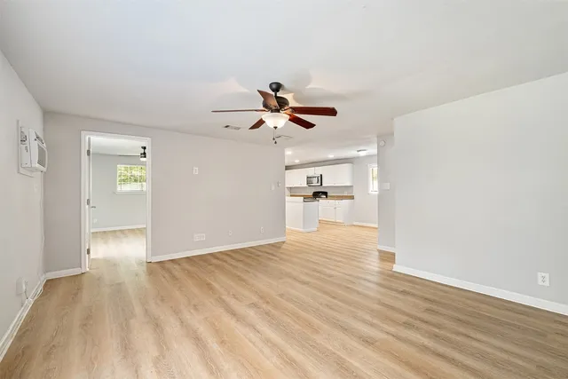 a view of empty room with wooden floor