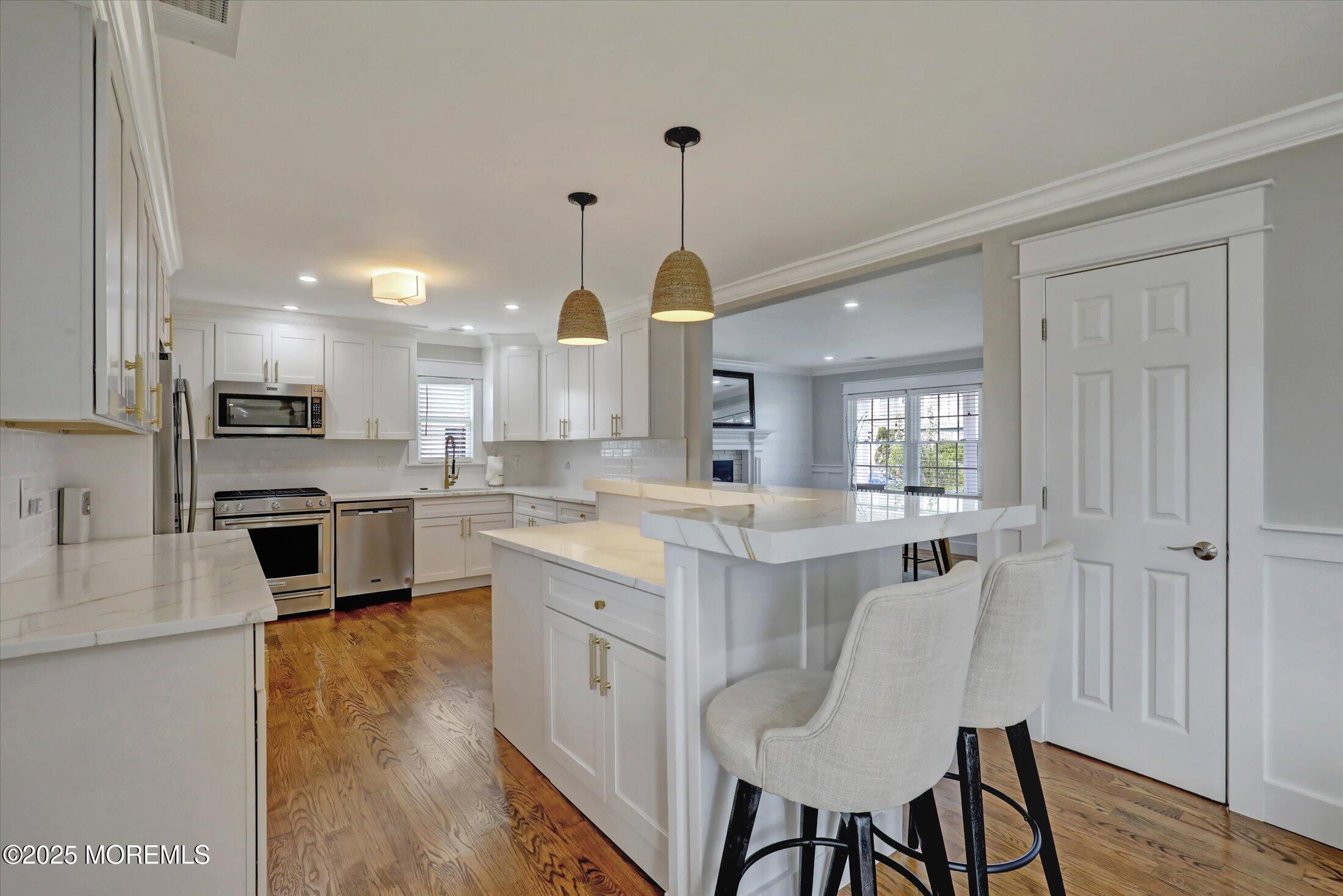 1810 Shore Boulevard Point Pleasant, NJ 08742 - Photo 20 of 49 a kitchen with stainless steel appliances kitchen island granite countertop a stove a sink dishwasher a dining table and chairs with wooden floor