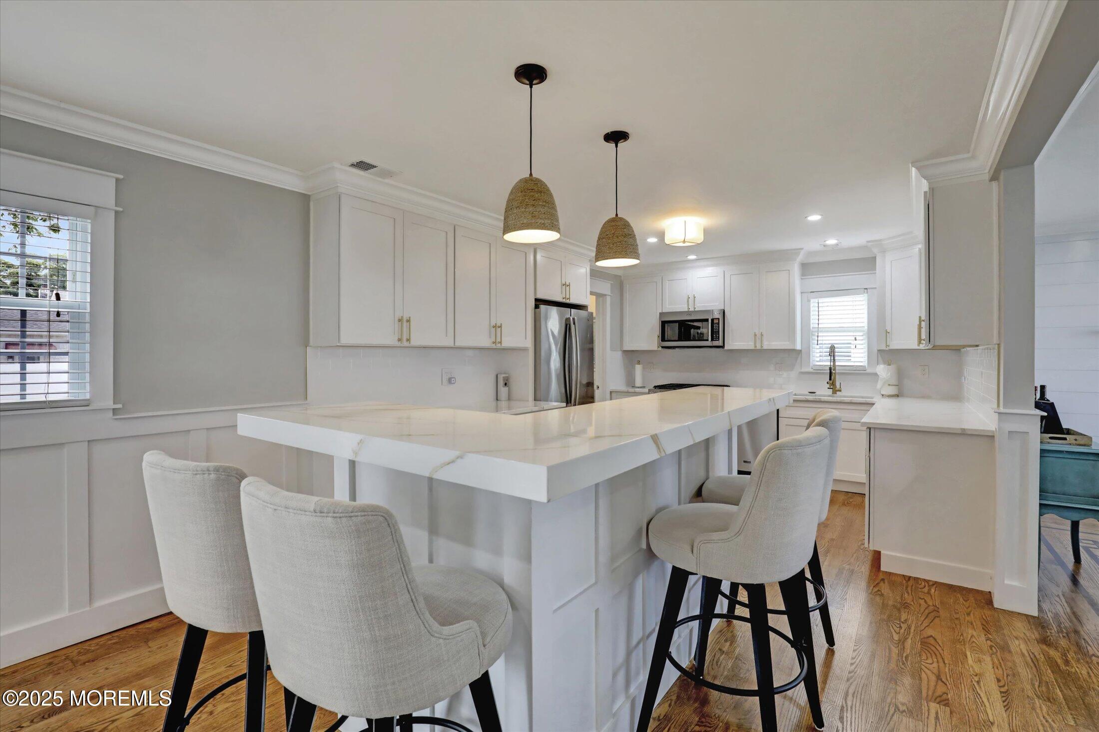 1810 Shore Boulevard Point Pleasant, NJ 08742 - Photo 21 of 49 a kitchen with a dining table chairs sink and cabinets