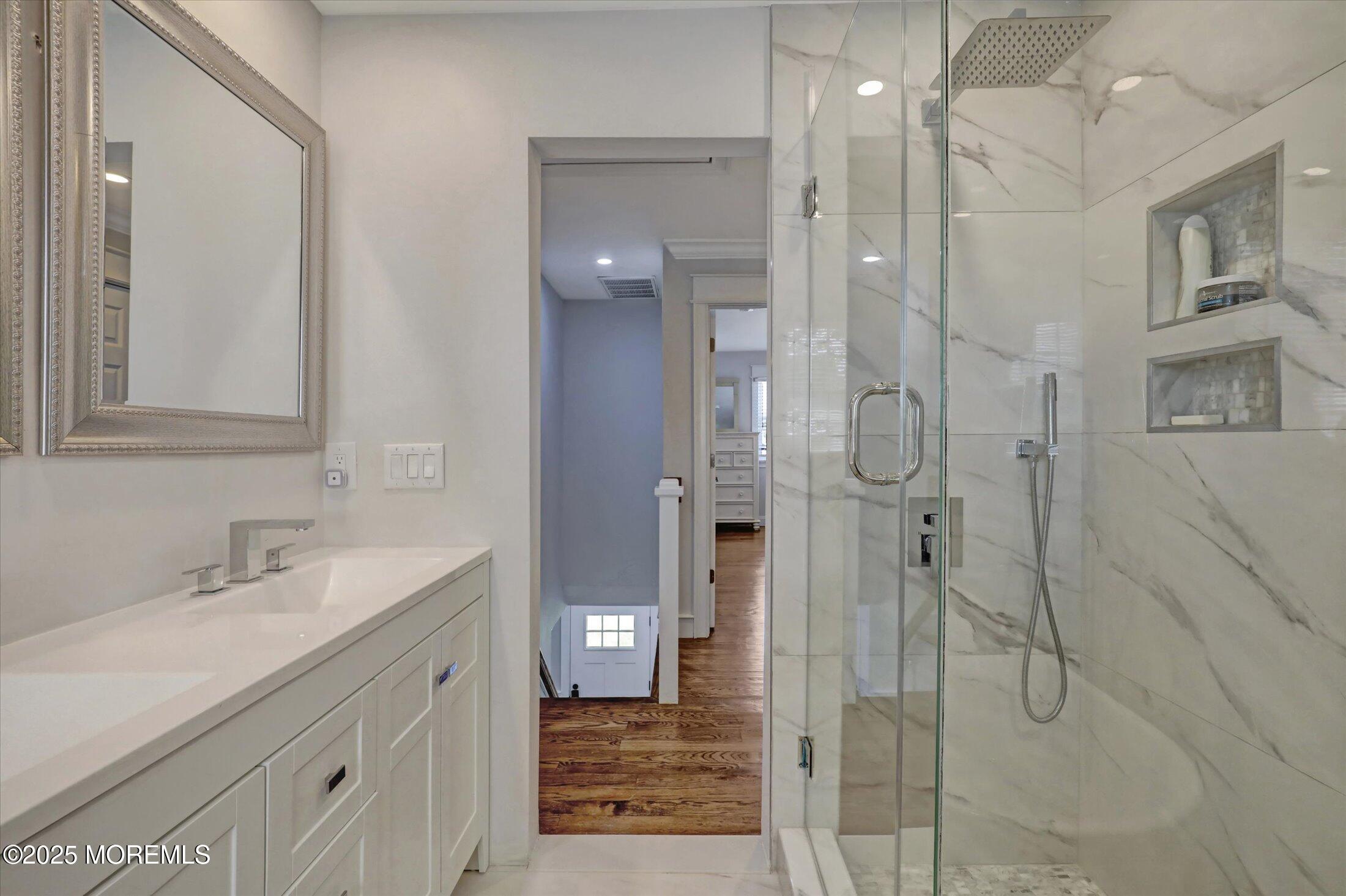 1810 Shore Boulevard Point Pleasant, NJ 08742 - Photo 34 of 49 a bathroom with a shower sink and mirror