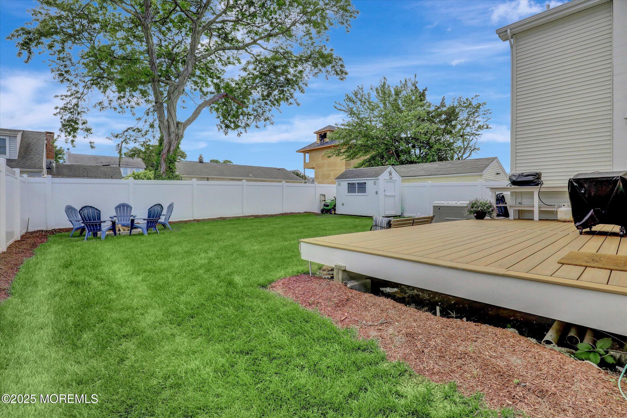 1810 Shore Boulevard Point Pleasant, NJ 08742 - Photo 44 of 49 a view of a backyard with table and chairs potted plants and large tree