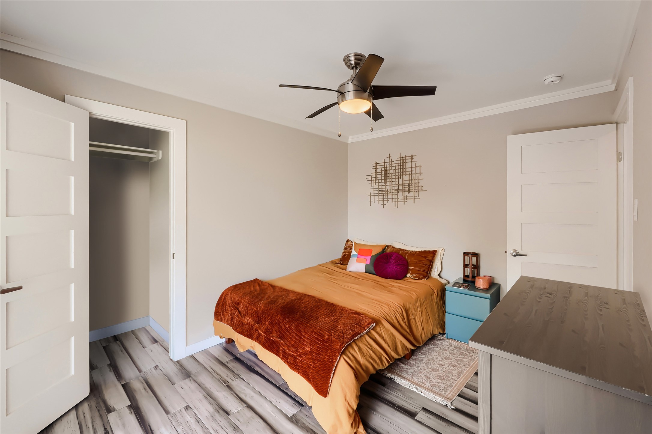 5707 Tracy Lynn Lane, Unit A Austin, TX 78721 - Photo 18 of 33 Bedroom with light wood-style floors, a closet, ceiling fan, and ornamental molding