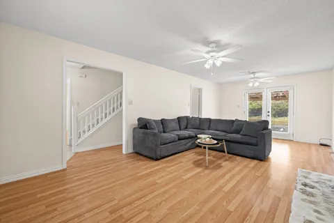 a living room with furniture and a wooden floor