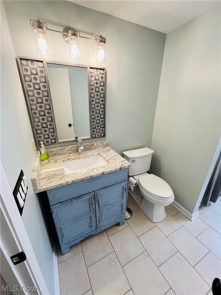 13655 Spring Street Burton, OH 44021 - Photo 38 of 48 Bathroom with oversized vanity, tile floors, and toilet