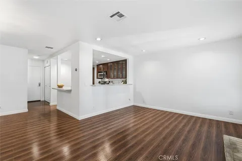 a view of a room with wooden floor and white walls