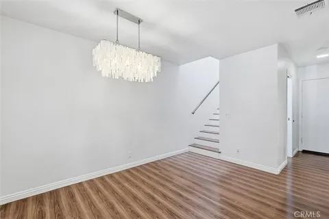 a view of a big room with wooden floor and windows