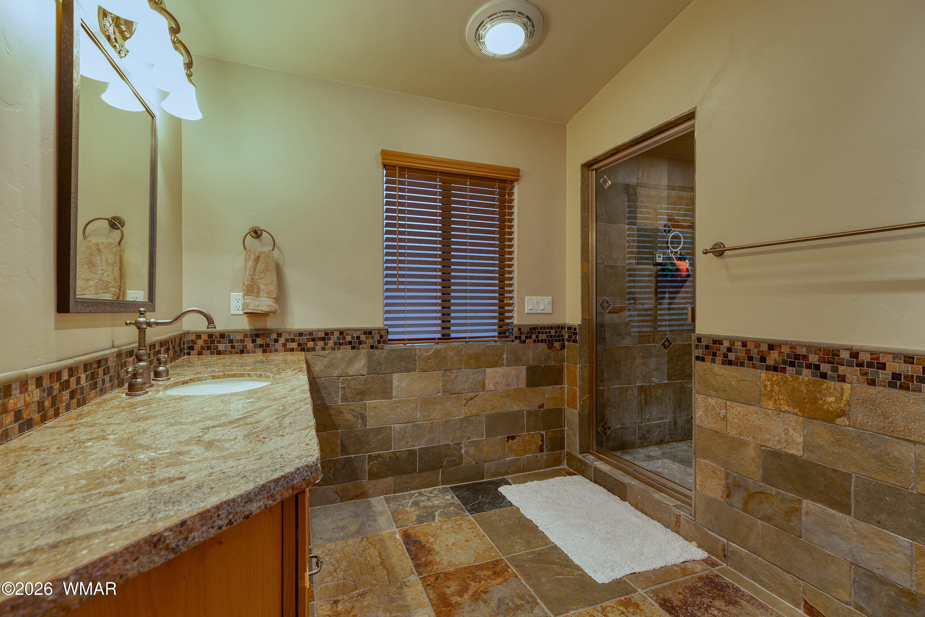 5155 Buck Springs Road Pinetop, AZ 85935 - Photo 21 of 37 a bathroom with a granite countertop sink a mirror and shower