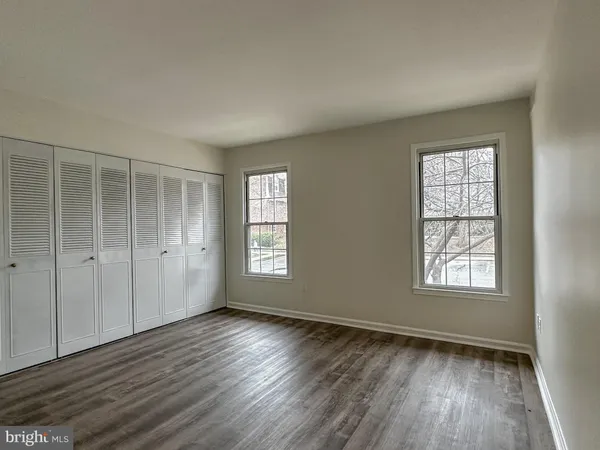 an empty room with wooden floor and window