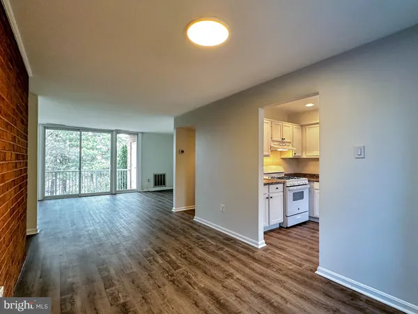 a view of empty room with wooden floor and window