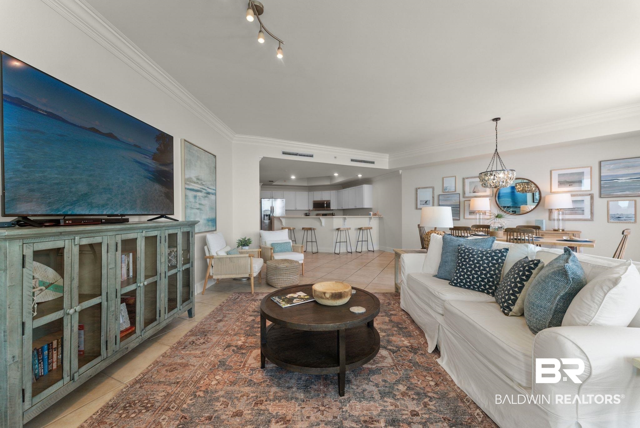 27580 Canal Road, Unit 1233 Orange Beach, AL 36561 - Photo 45 of 79 Living room featuring crown molding, light tile patterned floors, and a chandelier